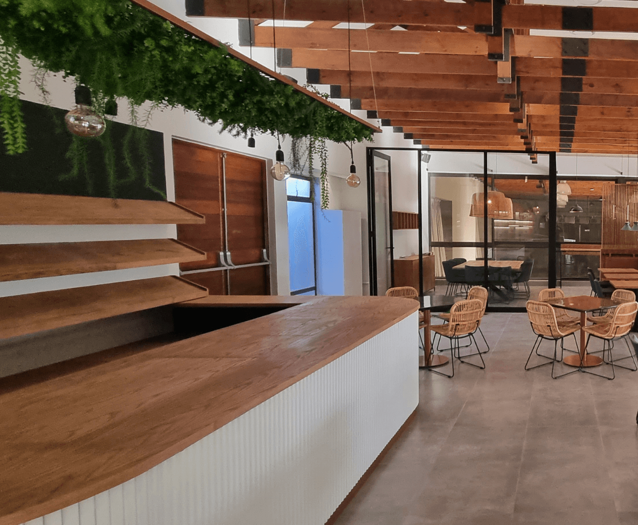 he interior of a coffee shop, highlighted by a large wooden ceiling and a bar for serving coffee and snacks.