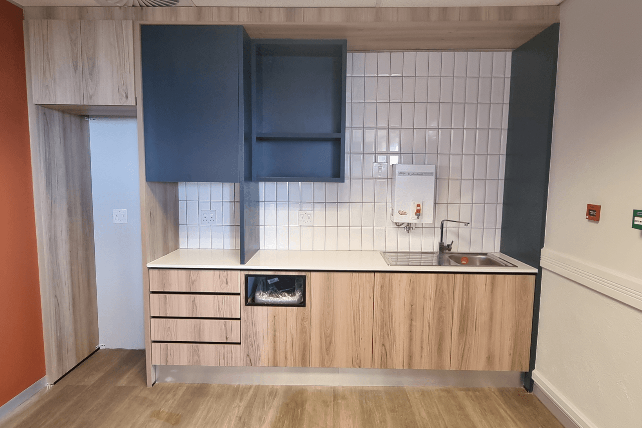 Compact office kitchen with a sink and cabinets in a small space.